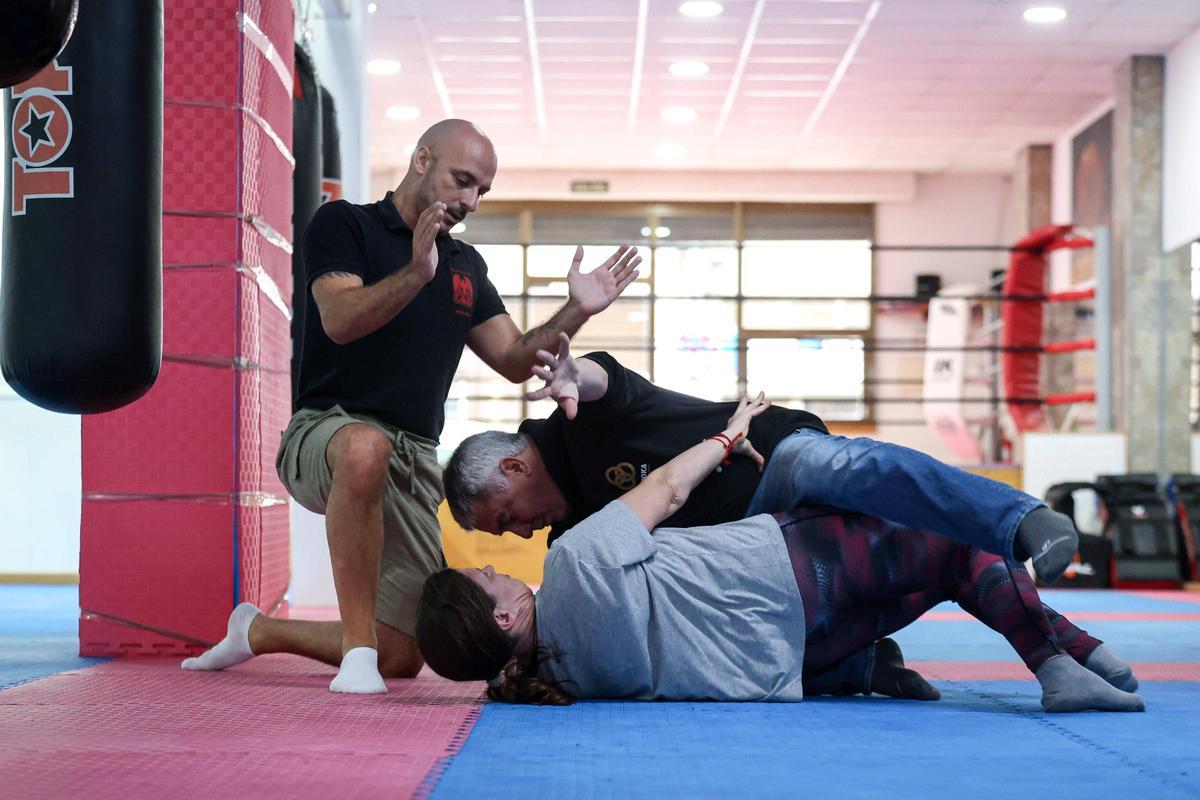 El coordinador Joan Roig realizando una de las técnicas aprendidas en el curso junto a la voluntaria Marian Seguí en el piso mientras que el entrenador Mirko Laffi, supervisa