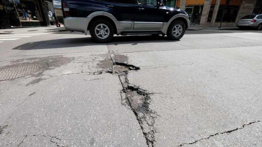 Uno de los baches, ubicado en el cruce entre las calles Numa Gilhou y Manuel Llaneza.