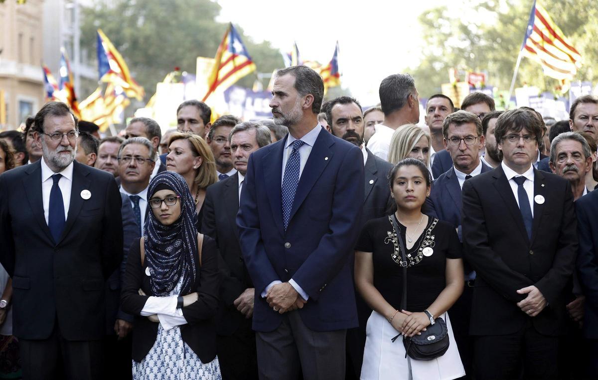 El rey Felipe VI, junto a los presidentes del Gobierno, Mariano Rajoy (i); de la Generalitat, Carles Puigdemont (d), en la cabecera de la manifestación contra los atentados yihadistas en Cataluña.