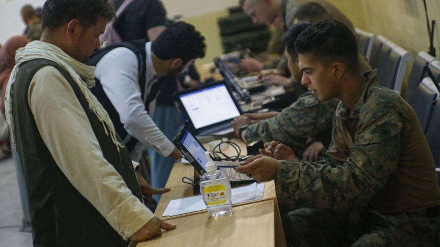 Militares norteamericanos controlan documentación de refugiados afganos en el aeropuerto de Kabul.