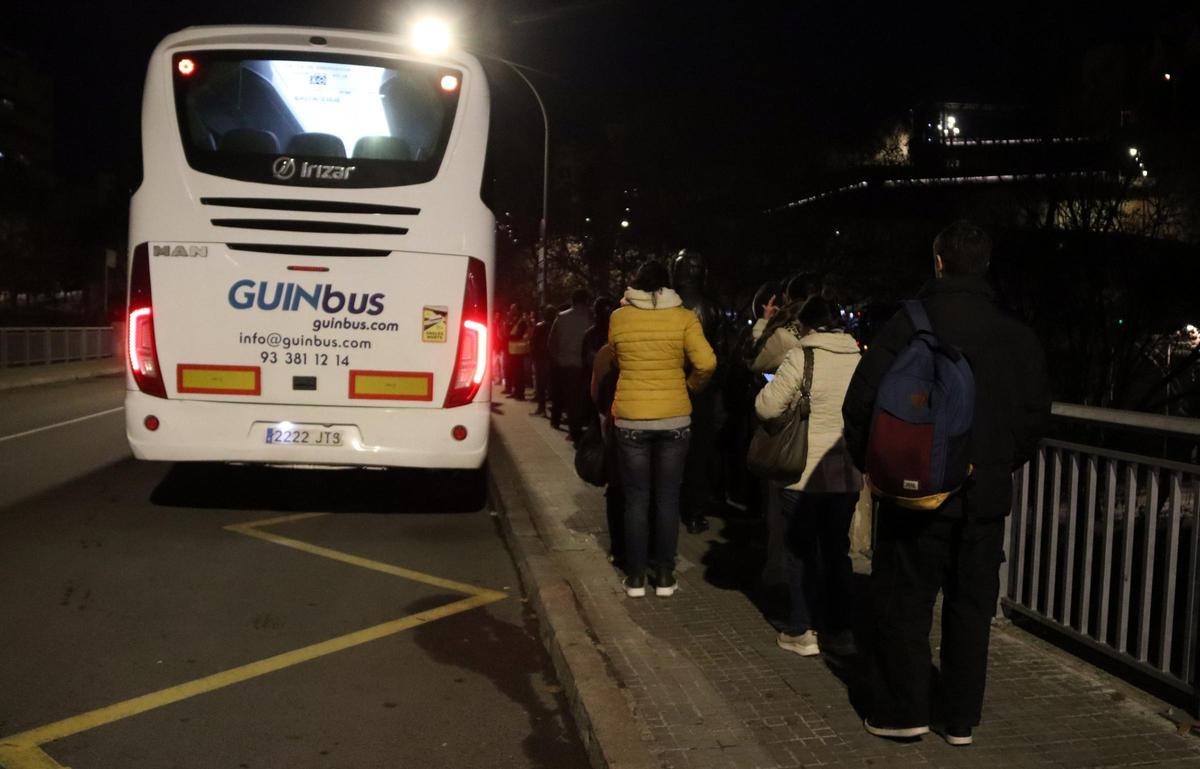 Persones fent cua per pujar a un autobús direcció Terrassa