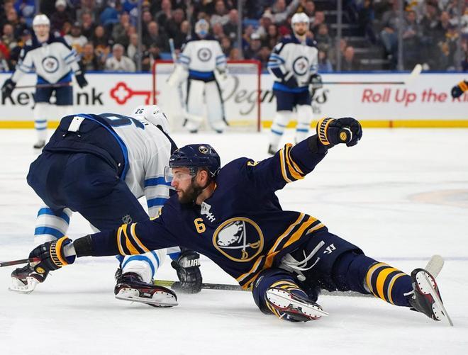 Blake Wheeler # 26 de los Winnipeg Jets es defendido por Marco Scandella # 6 de los Buffalo Sabres durante el primer período en KeyBank Center.