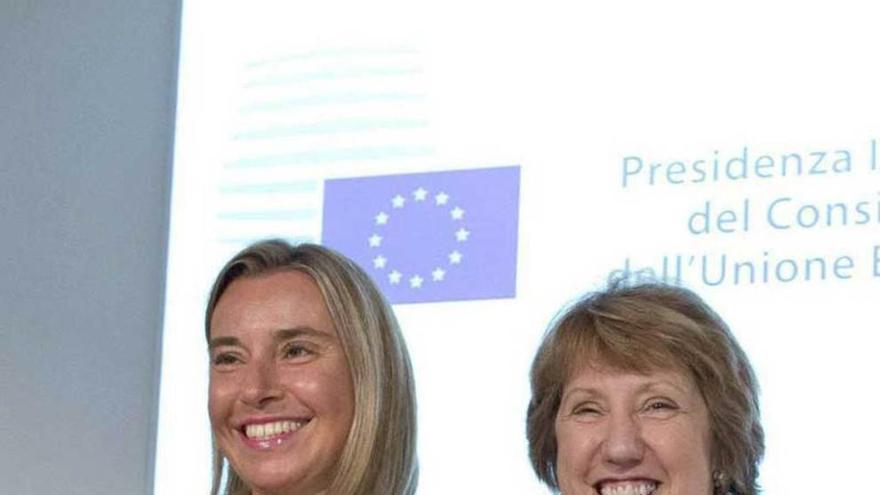 Mogherini y Ashton (derecha) se dan la mano en Milán, tras una reunión de ministros de Exteriores de la UE.