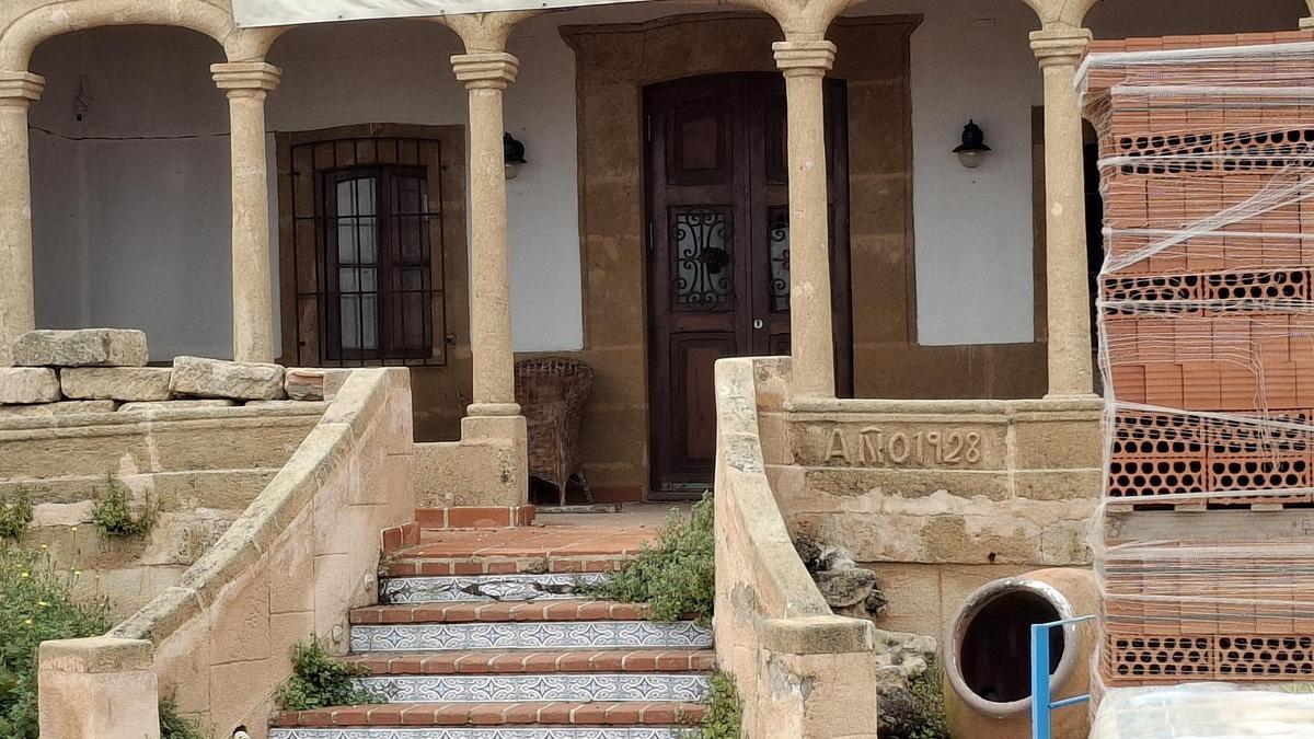 El porche con los arcos escarzanos y la fecha de construcción de la villa cincelada en la tosca