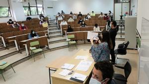 Una examinadora muestra uno de los exámenes de selectividad, antes de dar comienzo la prueba en un aula de la Facultad de Psicología de la Universidad de Santiago