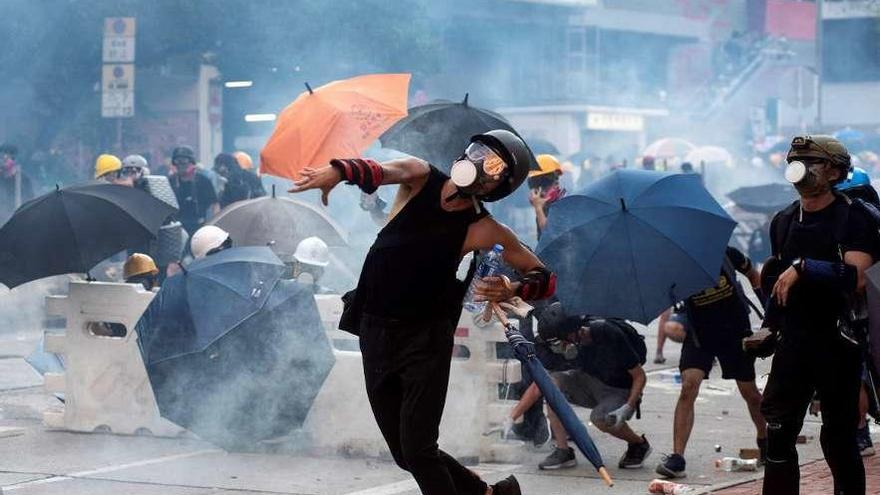 Manifestantes tiran ladrillos en reacción al gas lacrimógeno lanzado por la Policía de Hong Kong. // Efe