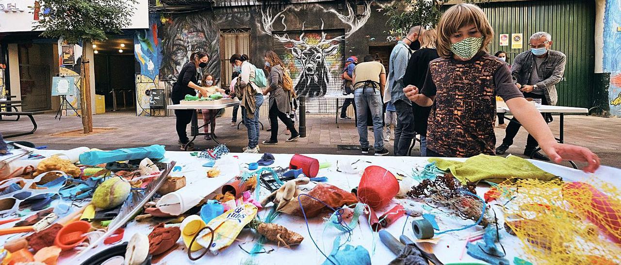 A l’esquerre, un taller de reciclatge a la porta del Teatre del Raval de Gandia. A la dreta, una de las actuacions musicals que s’han exhibit durant el festival. | LACASACALBA