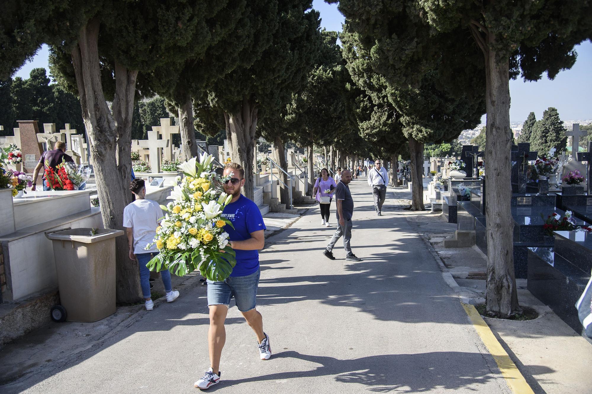 Un hombre carga un centro de flores amarillas y blancas, este martes en Cartagena