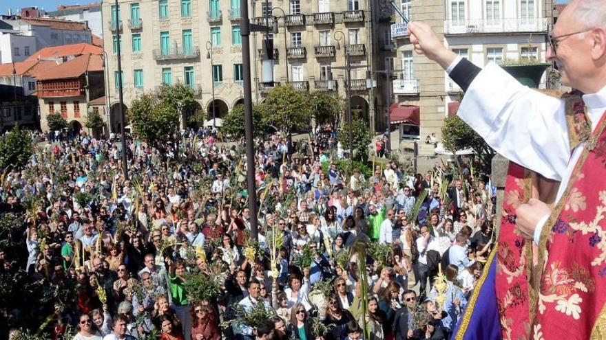 El sacerdote bendice desde el atrio de San Francisco las palmas y ramos de olivo de los fieles congregados en A Ferrería.  / Rafa Vázquez