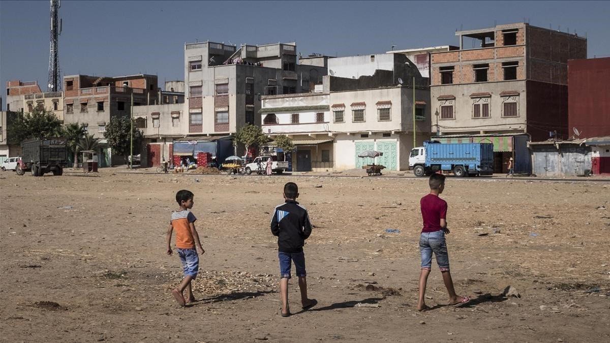 Unos niños juegan a fútbol en un descampado en un barrio de Alcazarquivir.