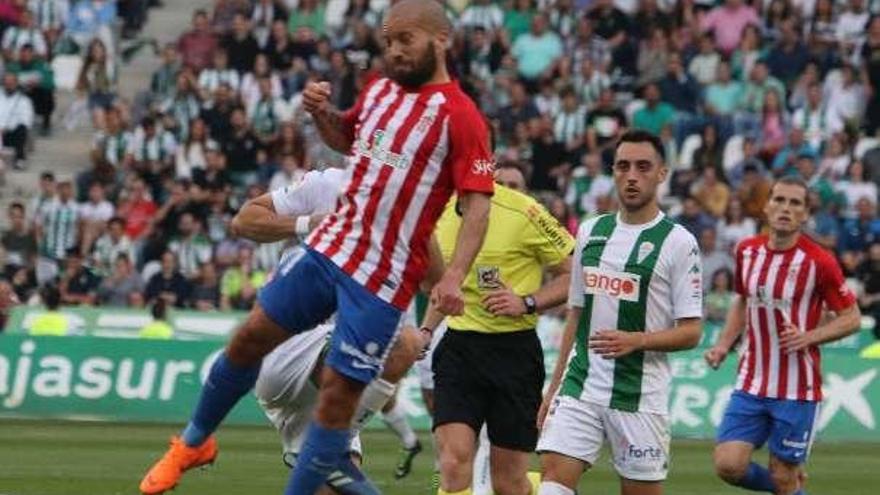 El defensa rojiblanco Lora lucha por un balón de cabeza en un momento del partido.