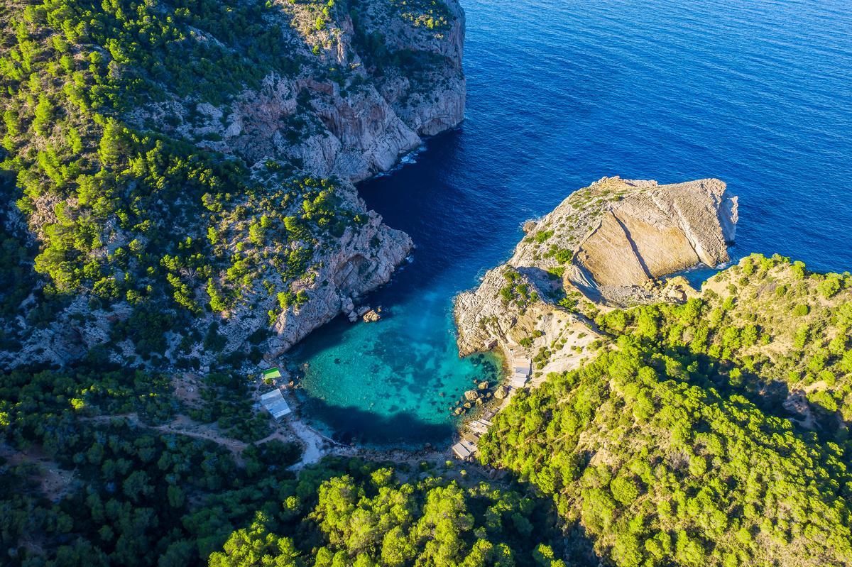 Aerial view of es Portixol, with turquoise waters and dramatic cliffs.