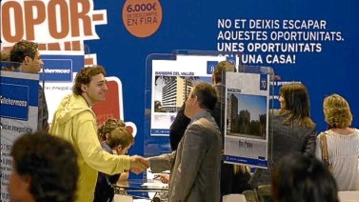 Visitantes y vendedores en un estand del salón inmobiliario Barcelona Meeting Point, ayer en Montjuïc.