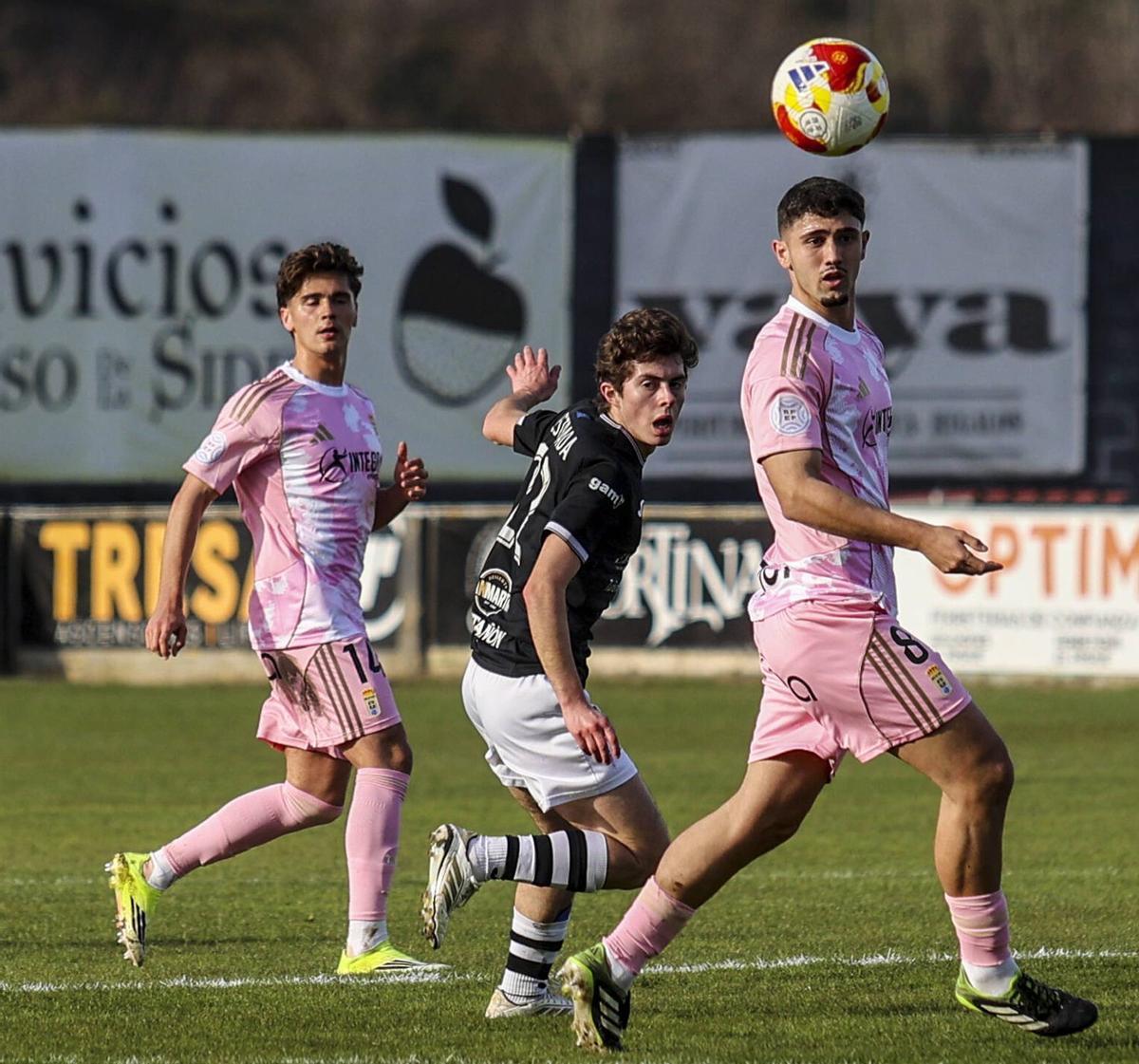 A la izquierda, Cheli y Agudín pugnan un balón con Nacho Estrada, ayer, en Les Caleyes. En el detalle, Carlos Cid y Omar Falah pugnan por un balón. | IRMA COLLÍN