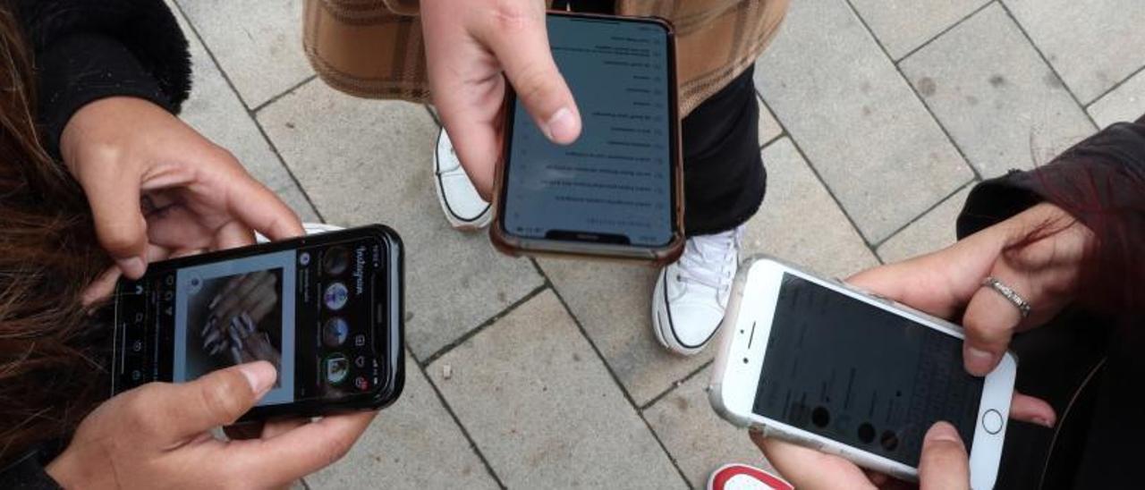 Jóvenes utilizando sus 
teléfonos móviles. // FdV