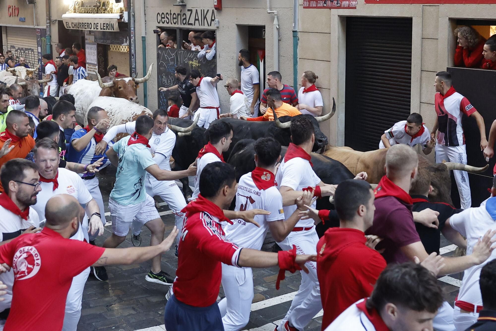 PAMPLONA, 13/07/2025.- Los mozos son perseguidos por los toros de la ganadería gaditana de La Palmosilla s durante el séptimo encierro de los Sanfermines 2025 este domingo en Pamplona. EFE/Villar López