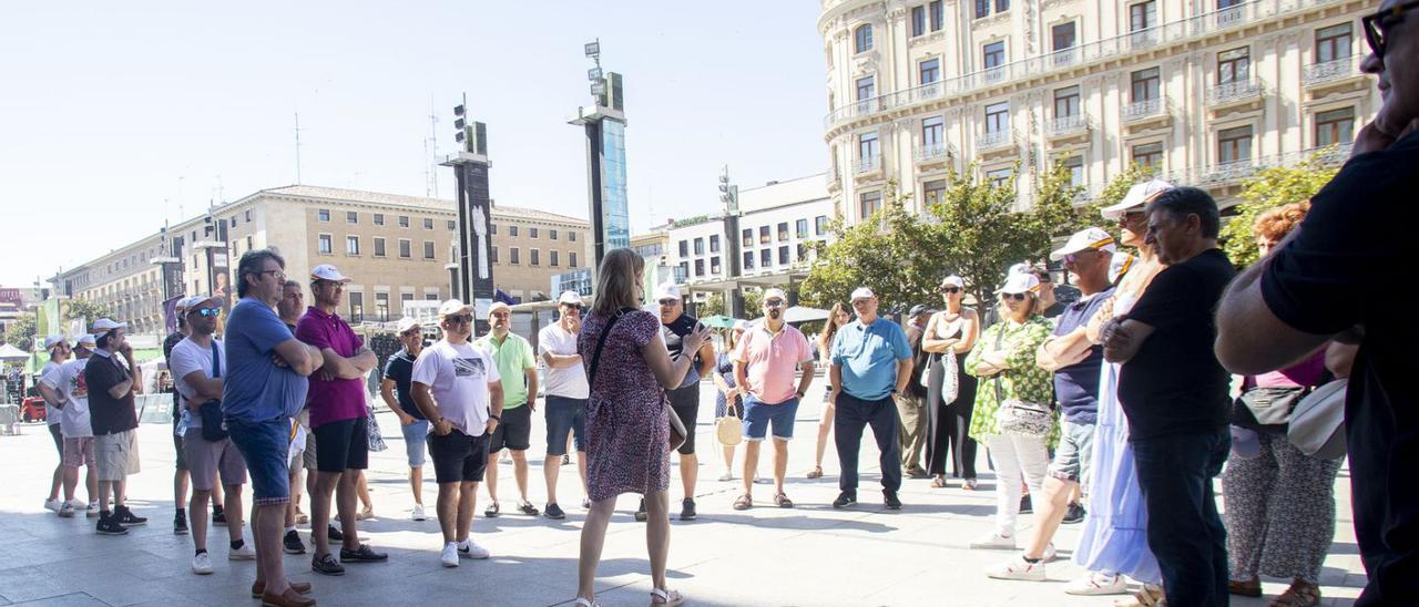 Un grupo de turistas atiende a las explicaciones de una guía en Zaragoza.