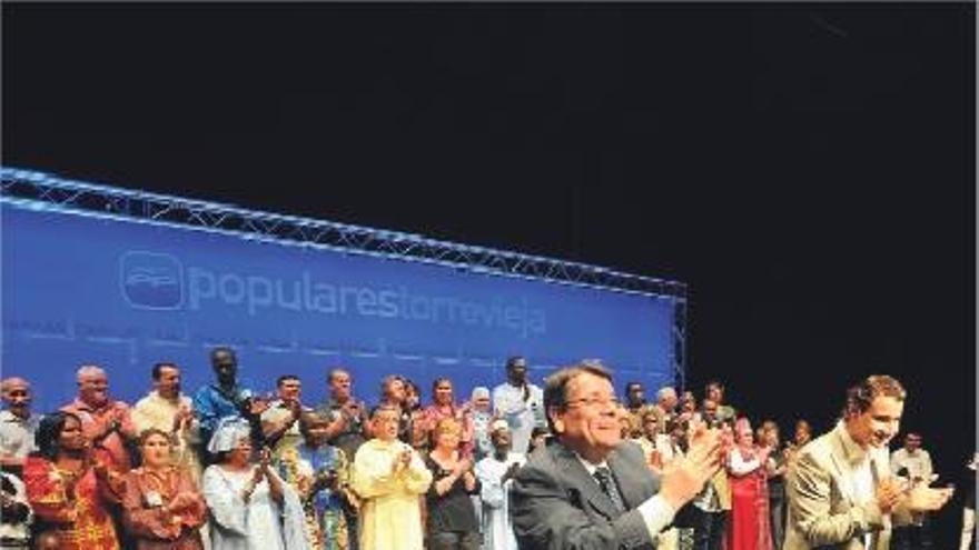 Un momento del acto con algunos de los residentes extranjeros sentados en el escenario.