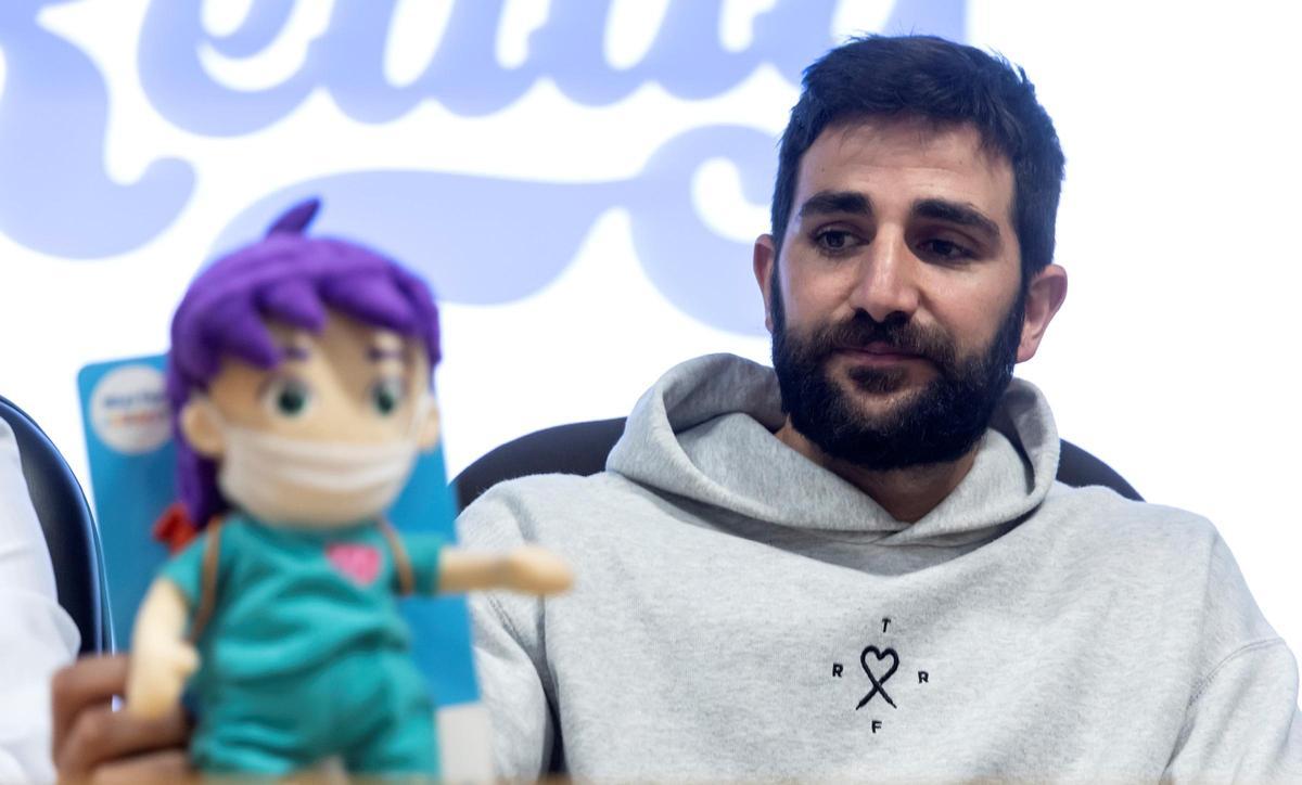 Ricky observa la mascota Nixxi, creada para hacer más dulce la estancia de los niños en el Hospital