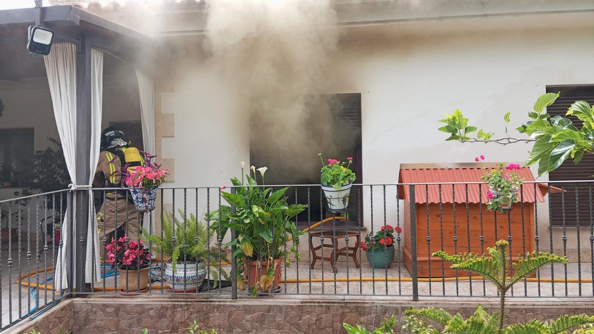 Los Bomberos del CEIS de Lorca trabajan en la extinción de las llamas en la vivienda.