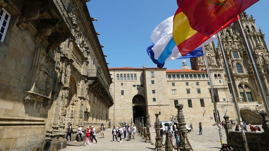 Un grupo de viajeros, ayer, en la entrada del Hostal dos Reis Católicos, en la Praza do Obradoiro, el ‘corazón’ del casco histórico / JESÚS PRIETO