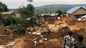 Varias personas observan los destrozos que provocaron inundaciones y corrimientos de tierra en las afueras de Kinshasa, República Democrática del Congo.