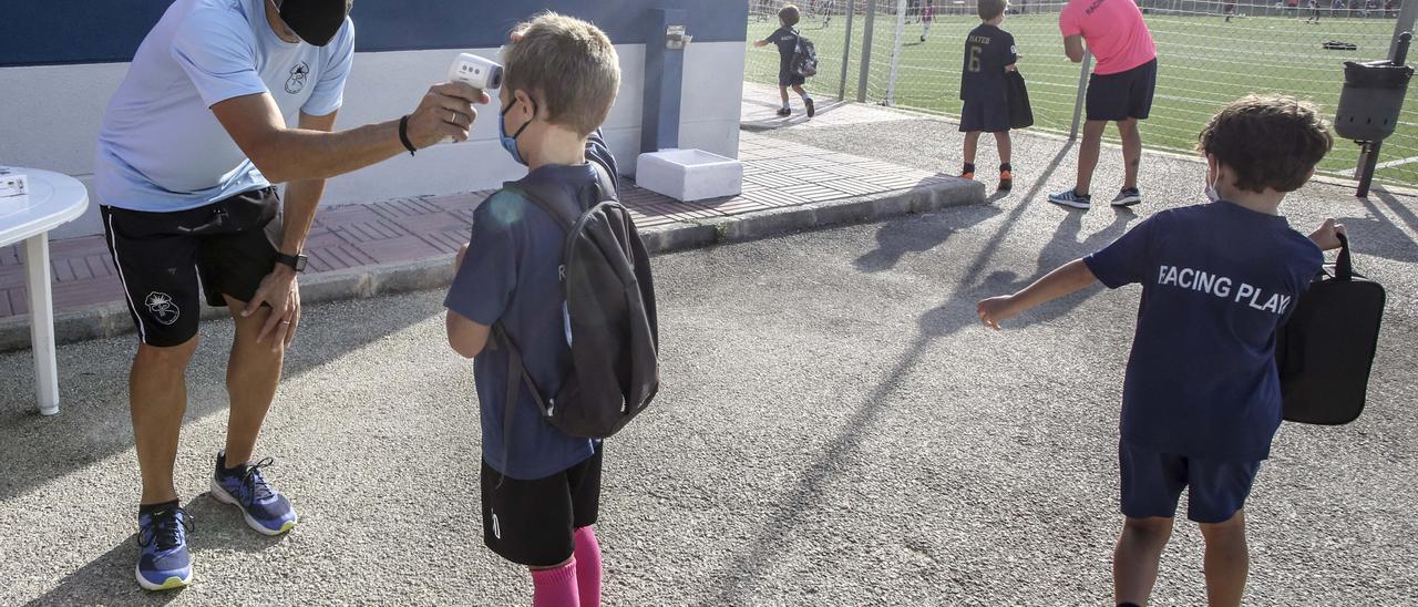 Un técnico toma la temperatura antes de un entrenamiento de un equipo infantil en el Cabo.