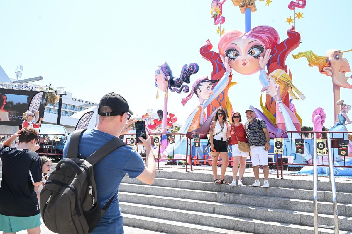Visitantes se fotografían junto a un monumento durante las Hogueras de 2025.