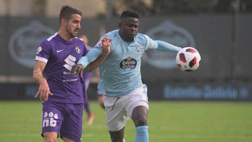 Emmanuel Apeh pugna por el balón con un futbolista del Burgos, ayer, en Barreiro. // Eugenio Álvarez