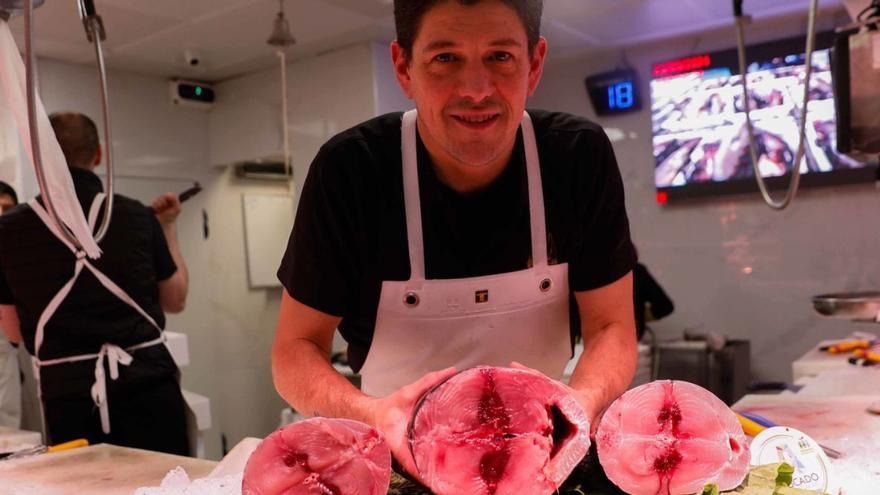 El pescadero Samuel Guillén muestra un tronco de bonito en su puesto de la plaza de abastos de Avilés. | Mara Villamuza