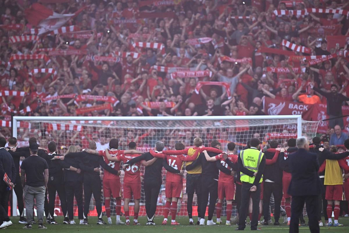 Liverpool players celebrate with their fans on the pitch after the English Premier League football match between Liverpool and Tottenham Hotspur at Anfield in Liverpool, north west England on April 27, 2025. Liverpool were crowned English champions for a record-equalling 20th time as a 5-1 rout of Tottenham on Sunday sealed their first Premier League title since 2020. (Photo by Paul ELLIS / AFP) / RESTRICTED TO EDITORIAL USE. No use with unauthorized audio, video, data, fixture lists, club/league logos or 'live' services. Online in-match use limited to 120 images. An additional 40 images may be used in extra time. No video emulation. Social media in-match use limited to 120 images. An additional 40 images may be used in extra time. No use in betting publications, games or single club/league/player publications. /. SEE CAPTION FOR MORE INFORMATION / RESTRICTED TO EDITORIAL USE. No use with unauthorized audio, video, data, fixture lists, club/league logos or 'live' services. Online in-match use limited to 120 images. An additional 40 images may be used in extra time