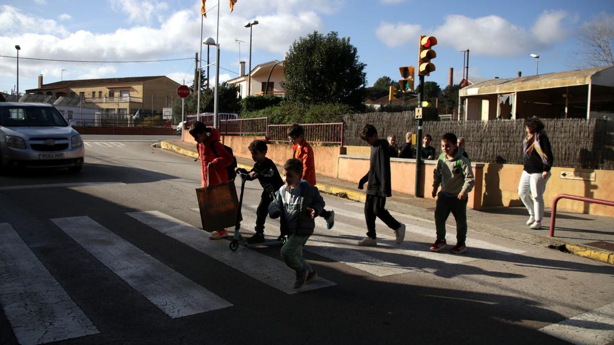 Infants travessant la carretera de Corçà que connecta els dos edificis de l'escola El Rodonell