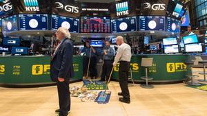 TOPSHOT - Personal sweep the floor after the closing bell of the Dow Industrial Average at the New York Stock Exchange on February 5, 2018 in New York.