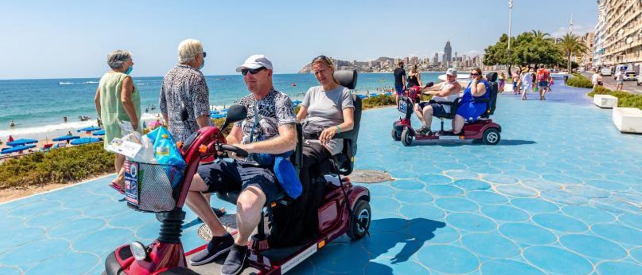 Turistas extranjeros pasean por uno de los paseos marítimos de Benidorm, este mes de agosto.  |