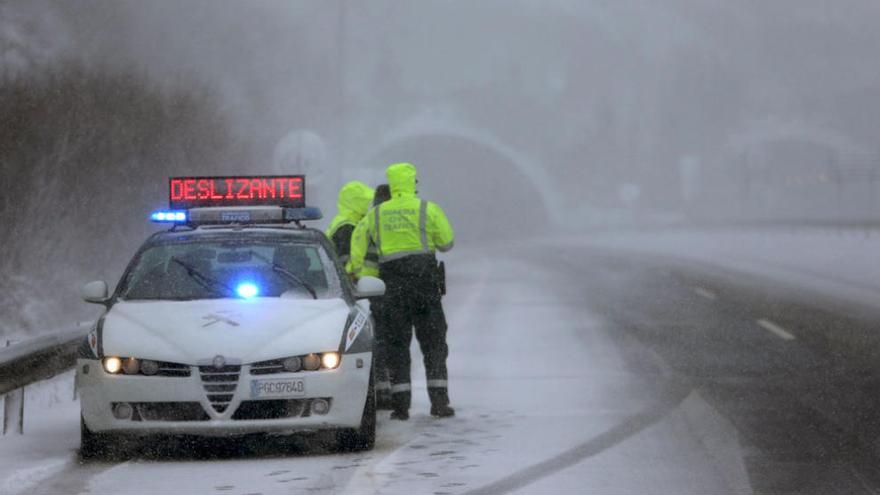 Una patrulla de Tráfico en la A 52, en el puerto de A Canda, donde la nieve complica la circulación.