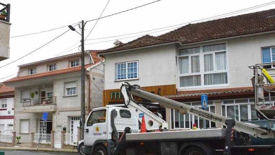 Operarios trabajando, ayer, en las farolas de Meira.   | GONZALO NÚÑEZ