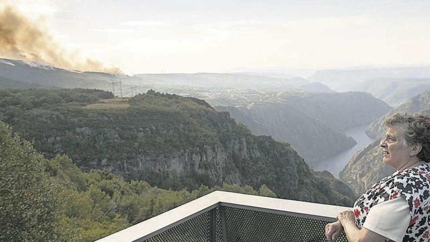 Una vecina observa el avance del incendio en el Cañón del Sil.