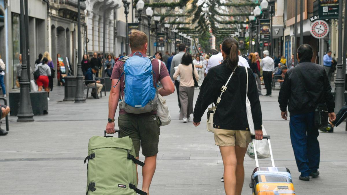 Una pareja de turistas camina hacia su hotel.
