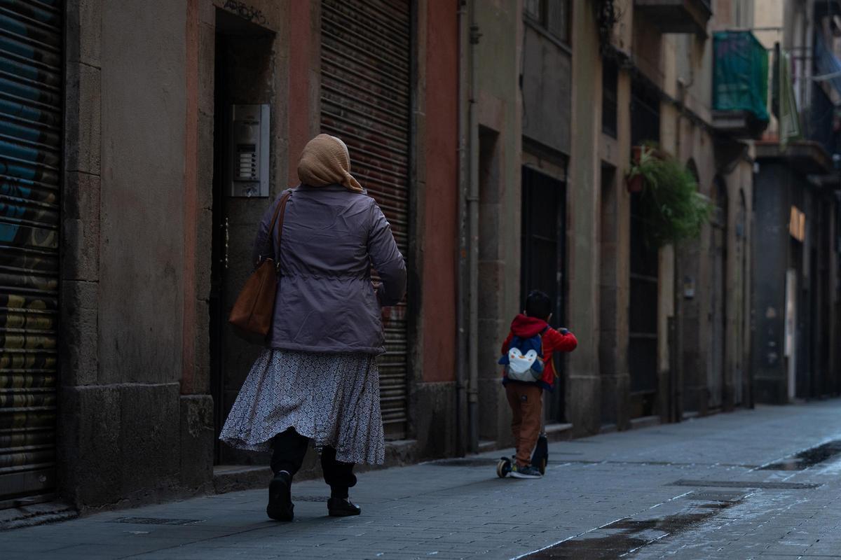Una mujer camina por la calle junto a su hijo, en una imagen de archivo.