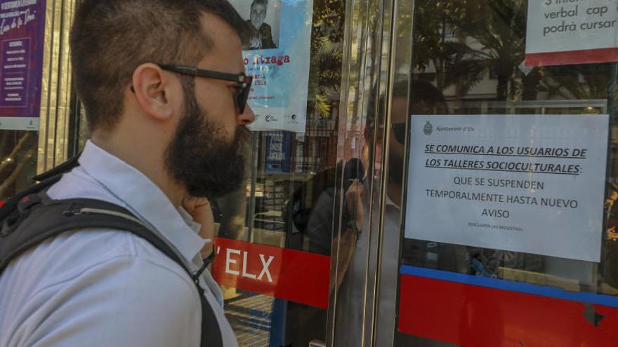 Un hombre lee ayer un cartel que anuncia la suspensión temporal de los talleres socioculturales.