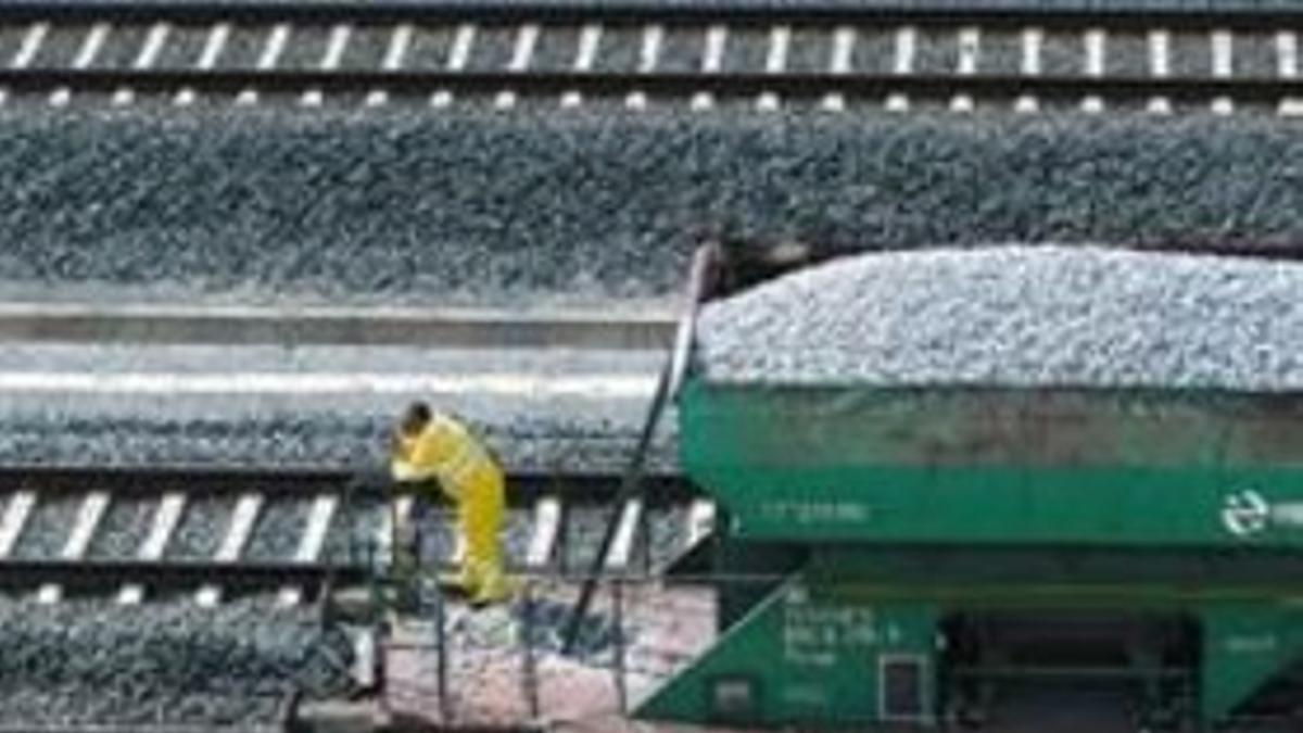 Un operario de Renfe en un vagón que descarga balasto sobre la zona en que ocurrió el siniestro.