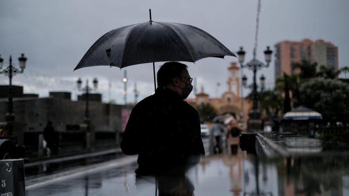 Un hombre se protege de la lluvia en Tenerife.