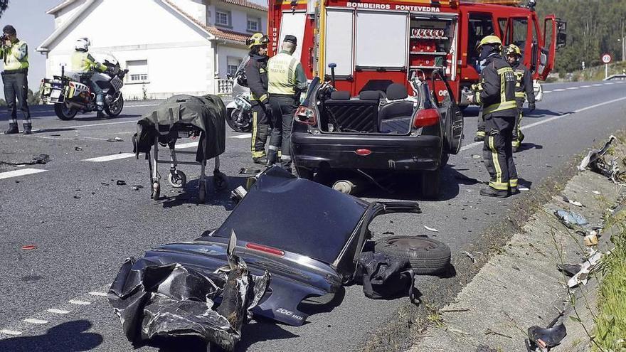 Guardia Civil y bomberos ante los restos del coche en el que viajaba la víctima, que quedó destrozado. // Rafa Vázquez