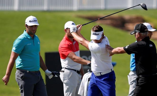 El golfista español Jon Rahm (i) observa al inglés Ian Poulter (2-d) mientras practica la víspera del torneo de golf DP World Tour Championship en Dubái (Emiratos Árabes Unidos), hoy, 14 de noviembre de 2018