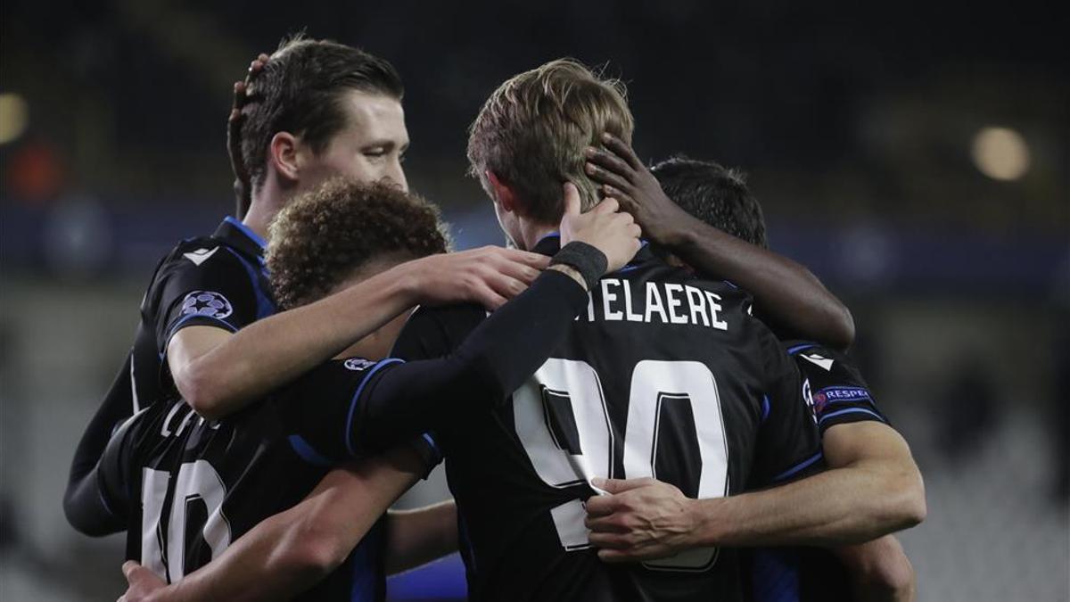 Futbolistas del Club Brugge celebrando abrazados un gol en Champions