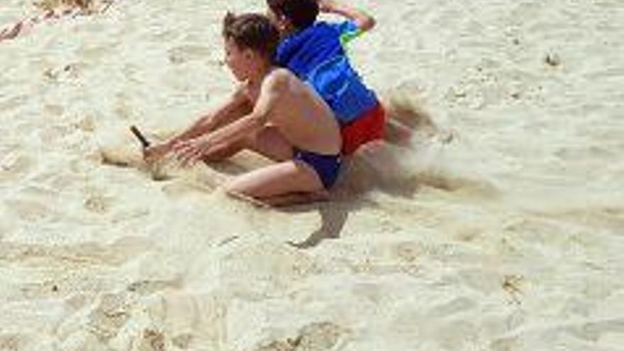 Dos jóvenes socorristas realizan ejercicios en la arena