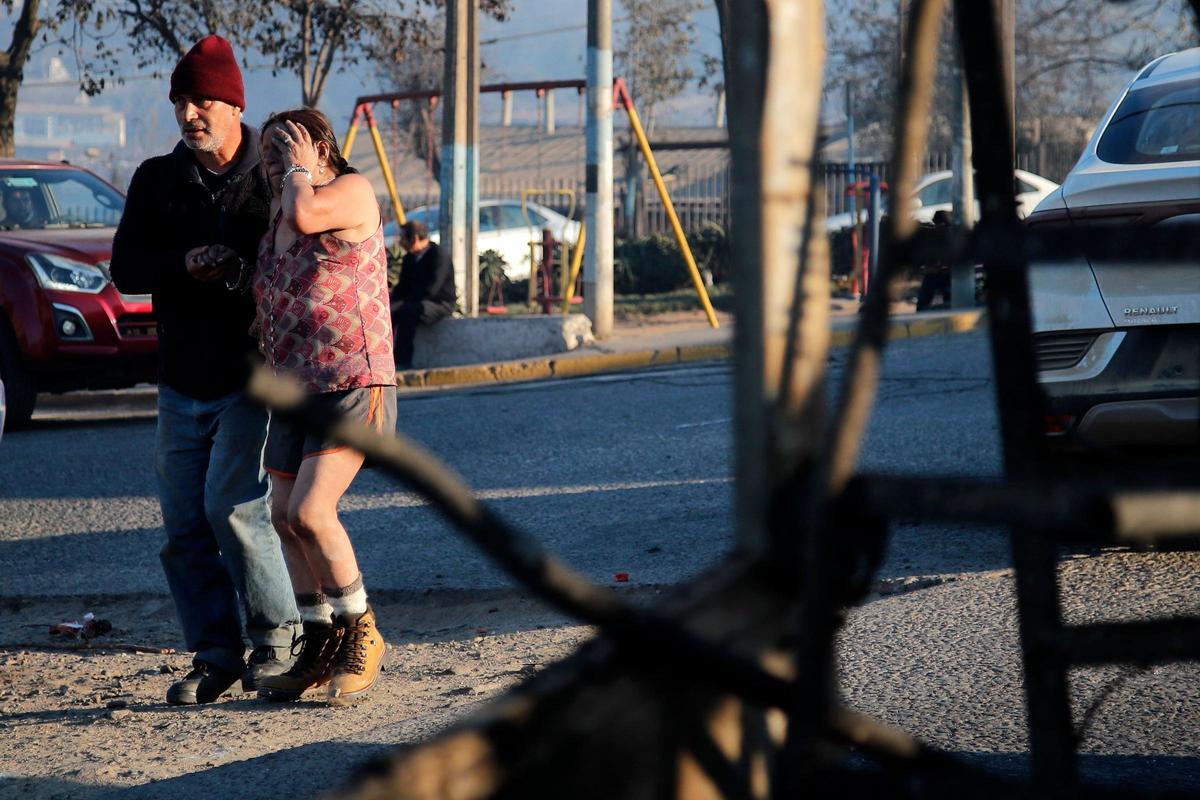 Una pareja llora mientras camina por una zona afectada luego de un incendio que afectó los cerros de Viña del Mar, Chile, el 3 de febrero de 2024. La región de Valparaoso y Viña del Mar, en el centro de Chile, amaneció el sábado con un toque de queda parcial para permitir el movimiento de evacuados y el traslado de equipos de emergencia en medio de una serie de incendios sin precedentes, informaron las autoridades.