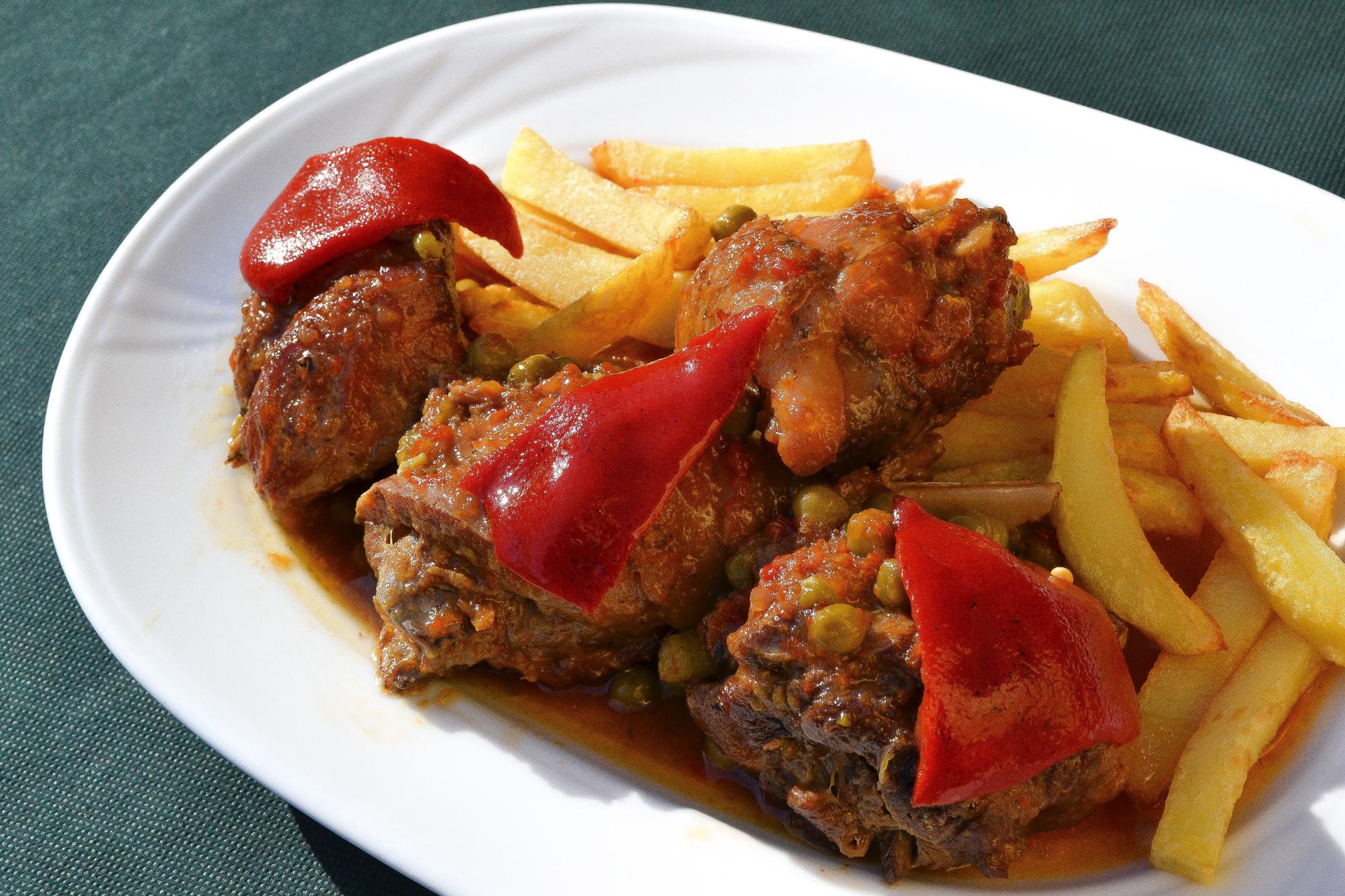 Pitu caleya guisado, con patatas fritas y pimientos.