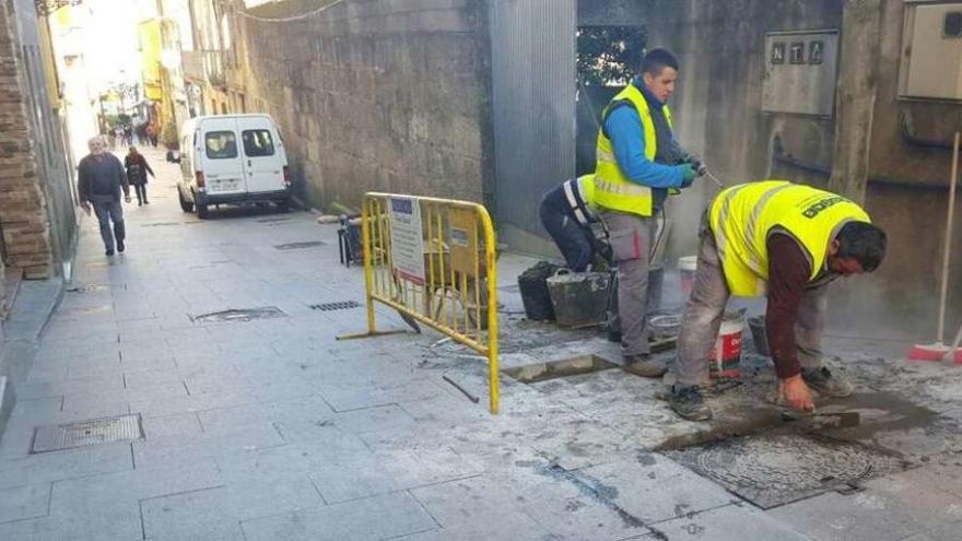 Los operarios reponen algunas losas de piedra deterioradas en el centro urbano de Marín. // S.A.