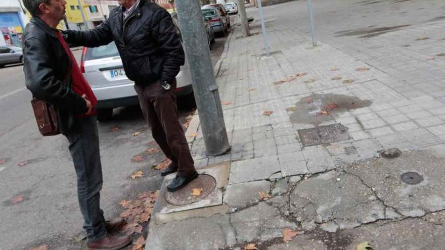 Fernández y Pérez conversan junto a una acera deteriorada.